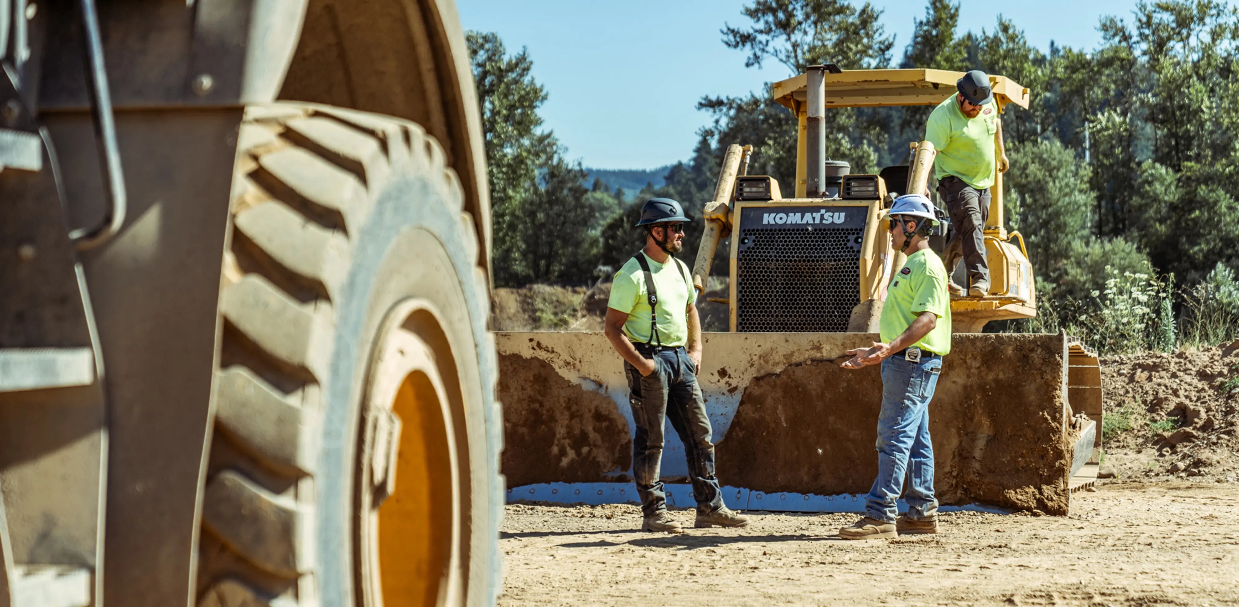 Two men in discussion wearing safety helmets.
