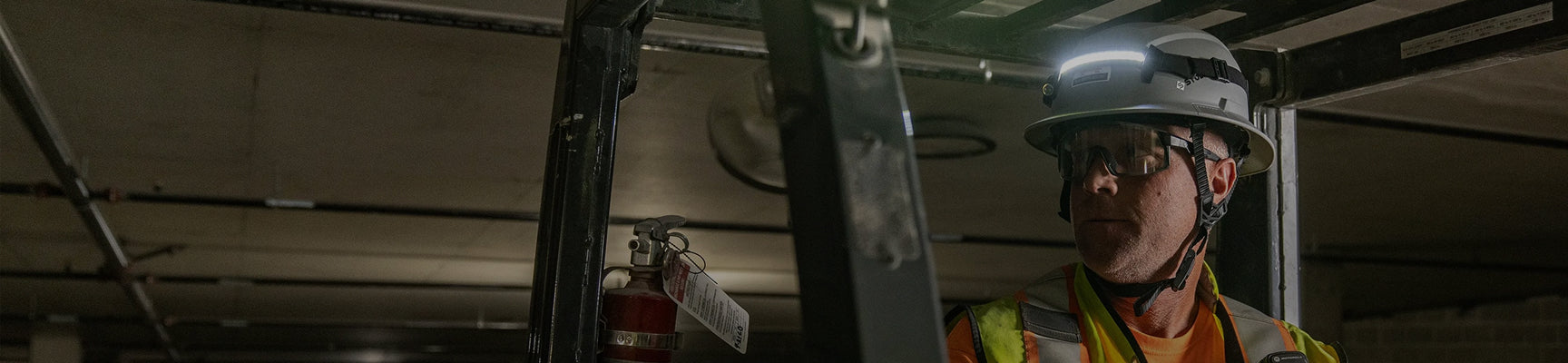 Person wearing a hard hat and safety vest in an industrial setting