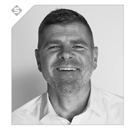 Black and white photo of a smiling person wearing a white shirt